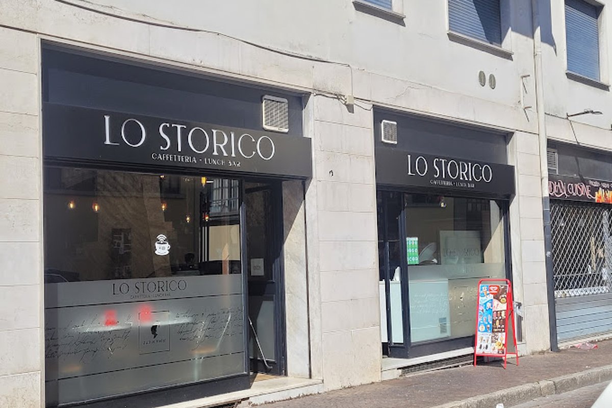 Due vetrine con insegne nere «Lo Storico Caffetteria · Lunch Bar», vetri smerigliati e facciata in pietra chiara
